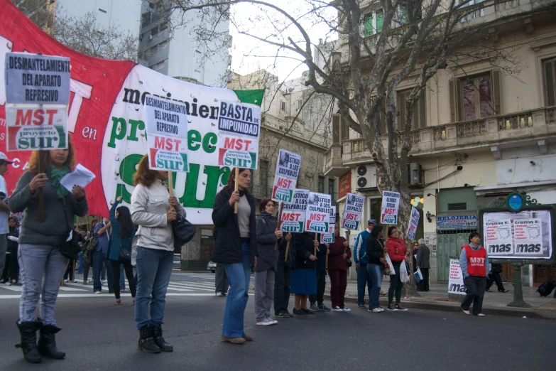 a group of people holding signs and flags during a protest