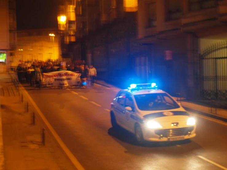 a police car with its lights on at an intersection