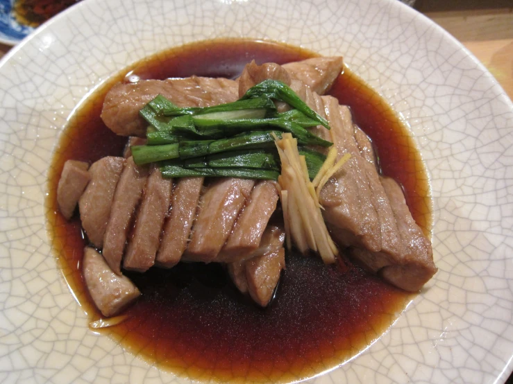 an asian dish with beef, asparagus and sauce