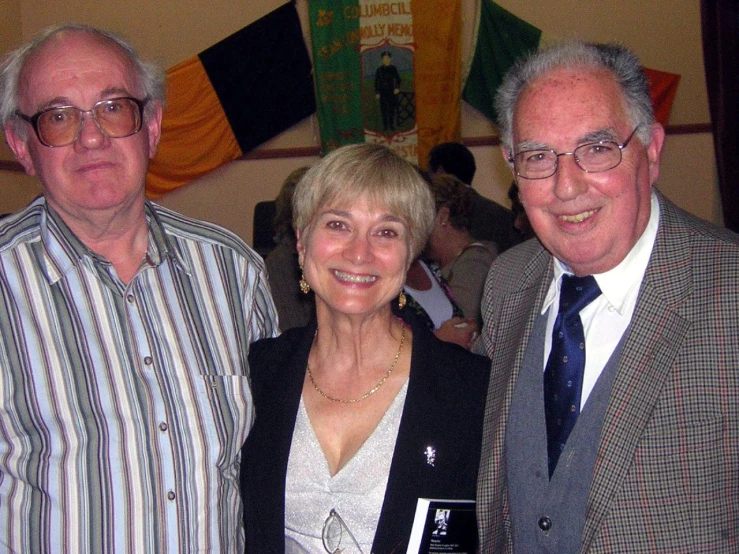 three men and one woman are smiling at the camera