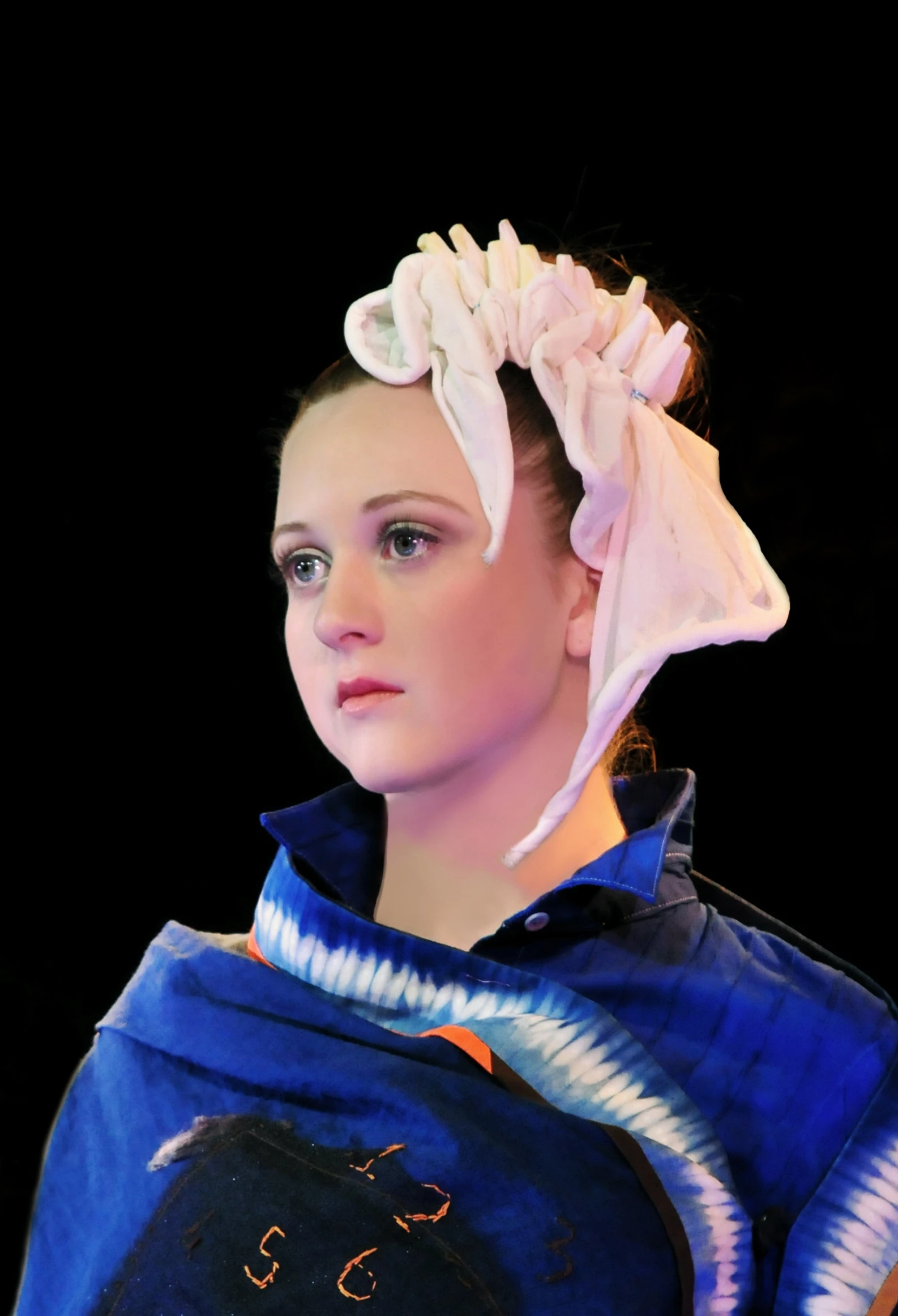 woman in blue sweater with white flowers on head