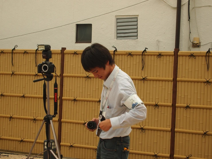 a boy holds a camera near a small camera