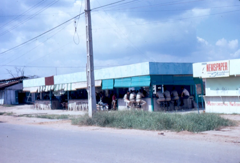 people in white shirts standing outside of a business