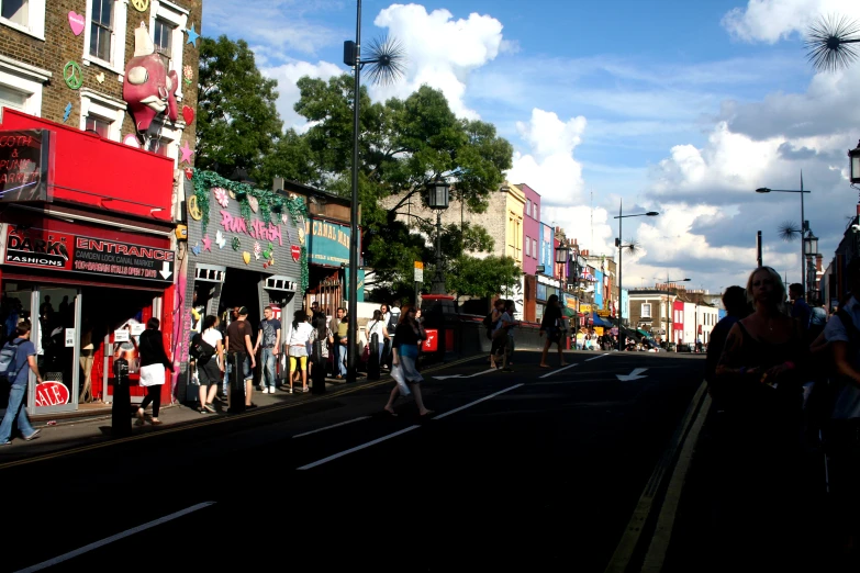 the group of people are walking down the street together