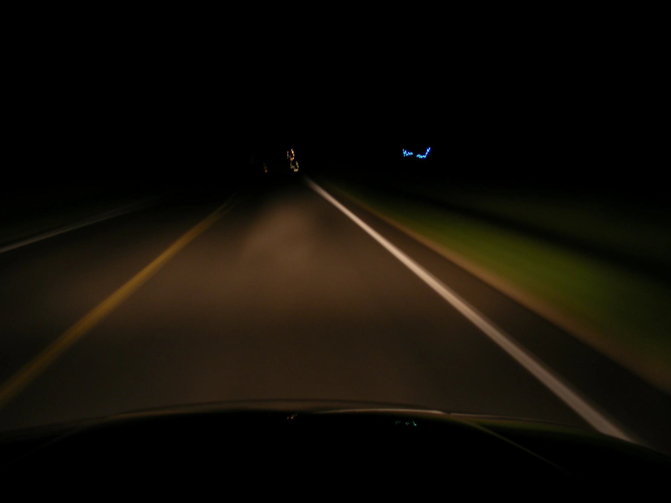 a car driving down a road at night