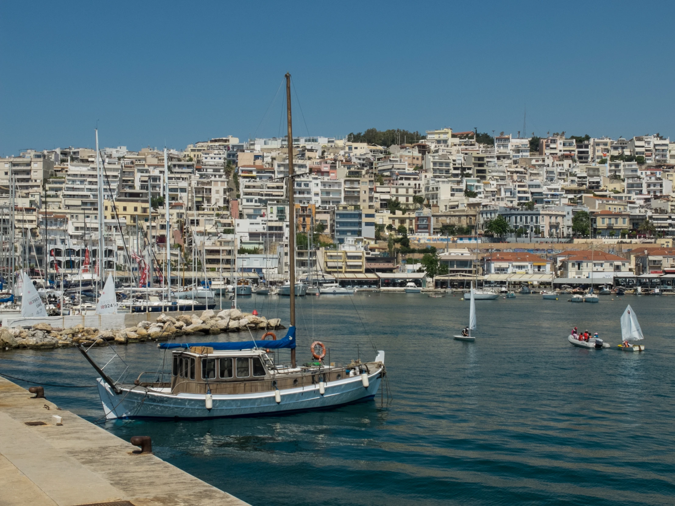 a small boat traveling through the water near a city