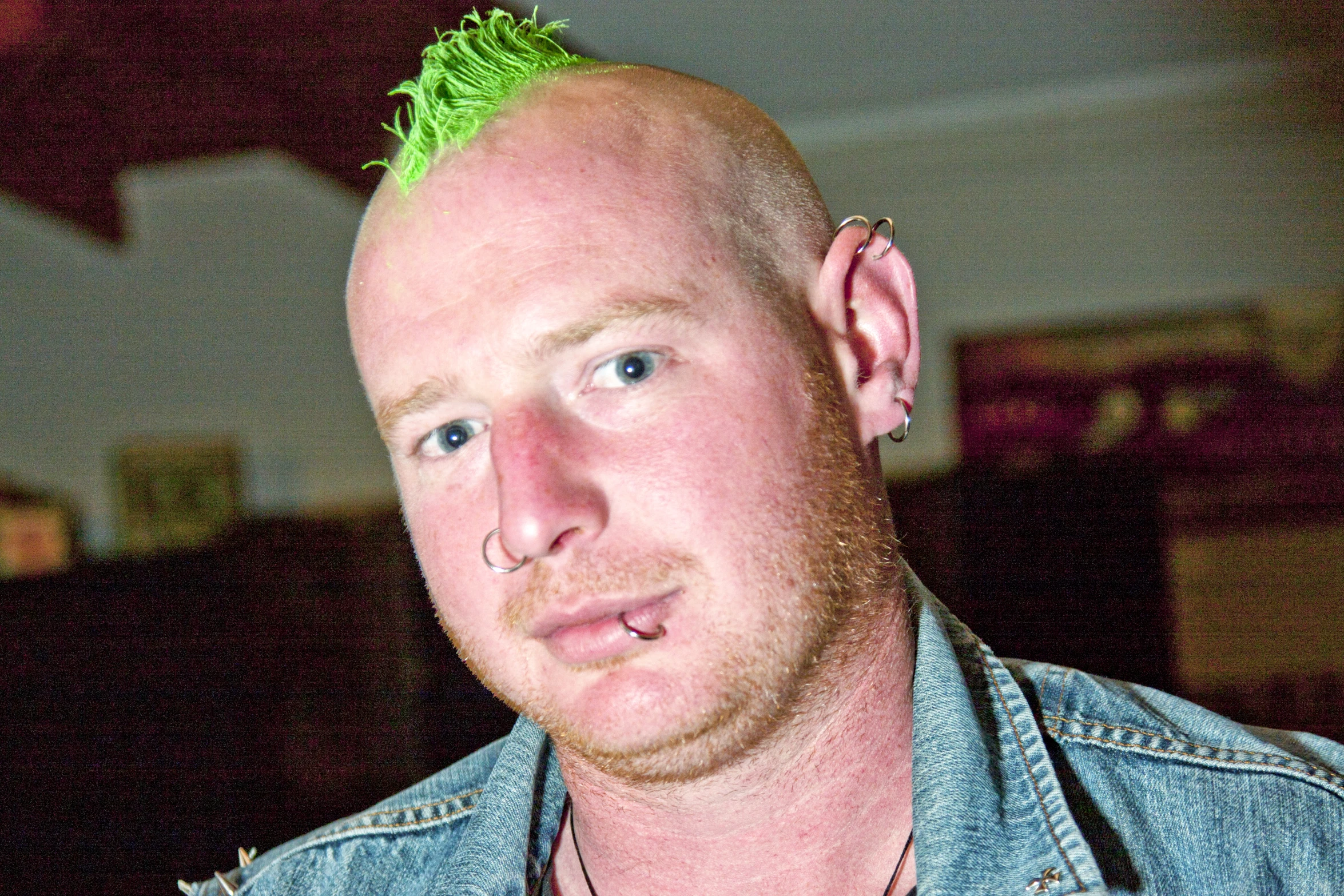 a young man with punk hair is looking at the camera