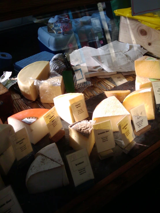 many different cheeses and cheese sauces are on the table