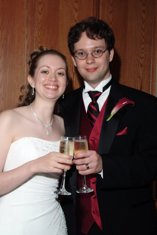 two people standing near each other with drinks in their hand