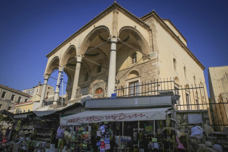 a large building that has columns and some stores