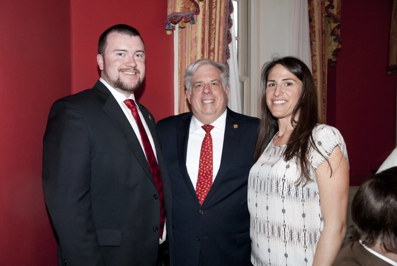 an older man standing with two women and a young man