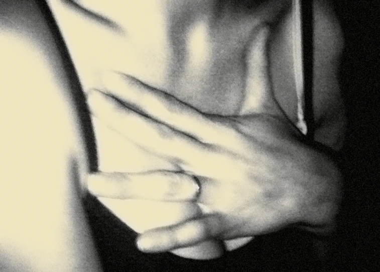 black and white pograph of a woman with her hands around her chest
