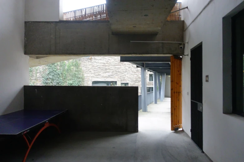 a ping pong table sits under a staircase leading to the bat