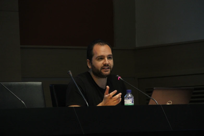 man sitting at a table with his hands open