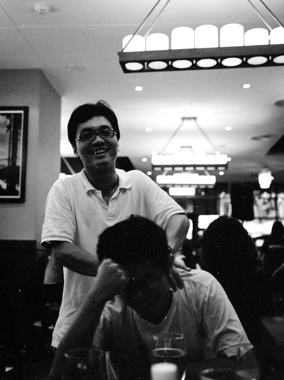 two men smiling at the camera in a restaurant