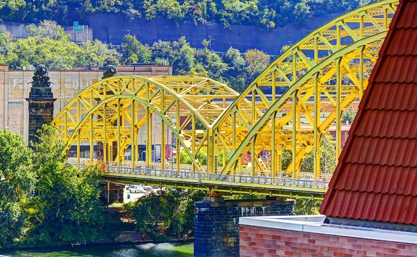 there is a yellow bridge spanning the width of a river