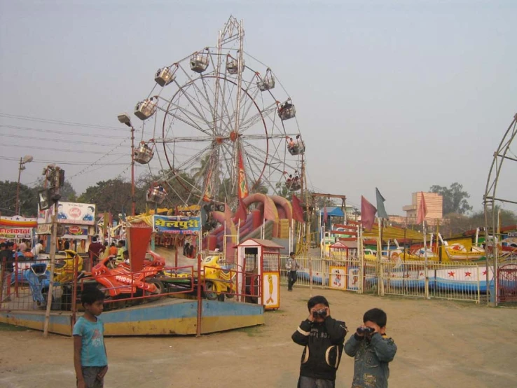 some people are standing around in front of the rides