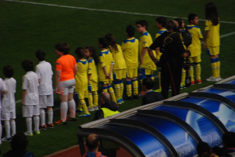 a group of soccer players standing on the sideline