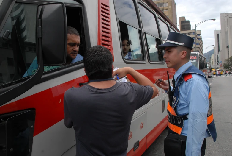 two police men are standing outside of a bus