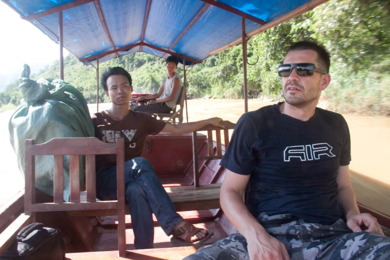 two men riding a bus together near people