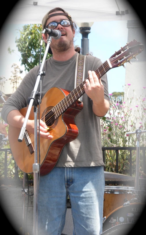 a man is playing a guitar with a microphone
