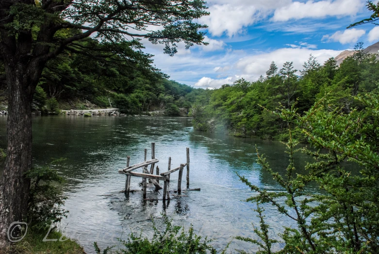a wooden dock sits in the middle of a river