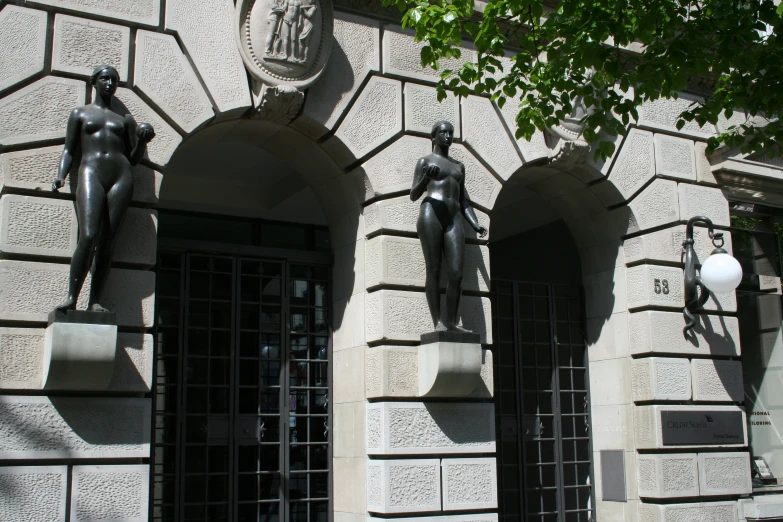 an outside view of a building with three statues