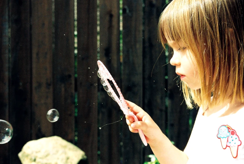 a  is blowing bubbles off of her hair