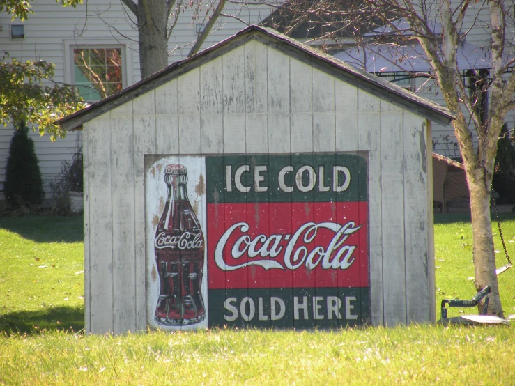 an old coke cola advertit painted on the side of a house