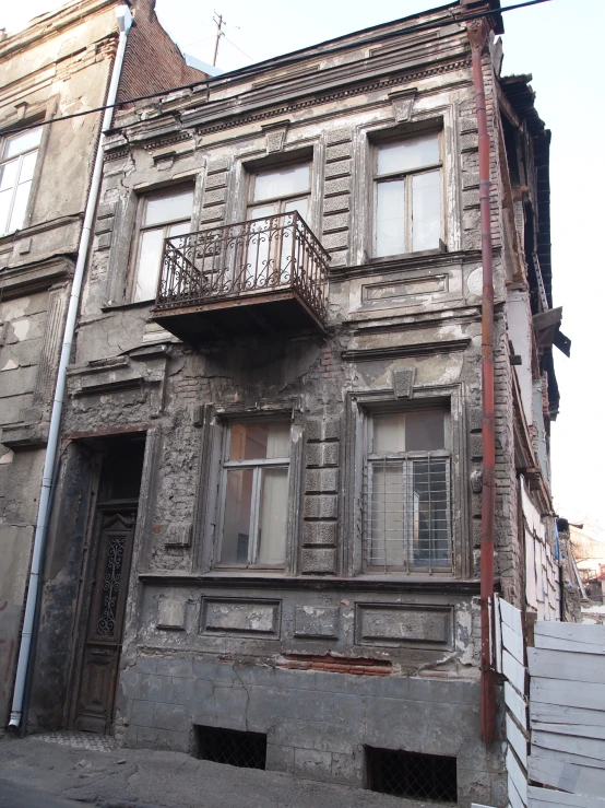 a building with two floors on the upper floor and a few windows above