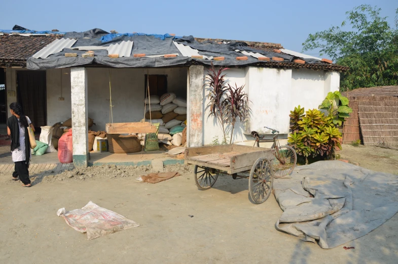 two people are standing outside of a small building