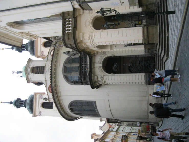 a group of people walking down a stone road in front of a church