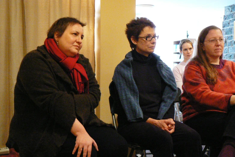 several people sitting on chairs waiting for someone to talk