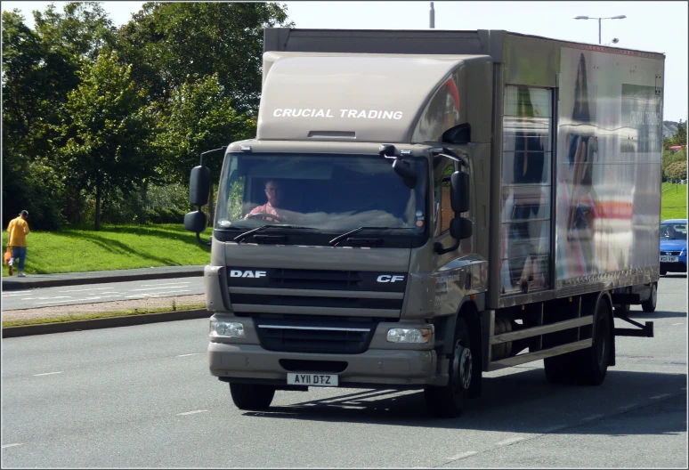 a truck driving on the street next to grass