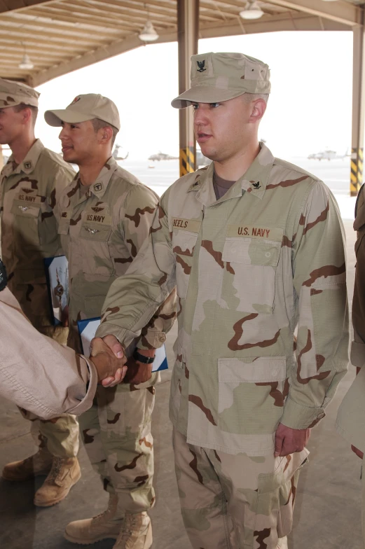 three men in uniform shaking hands near each other