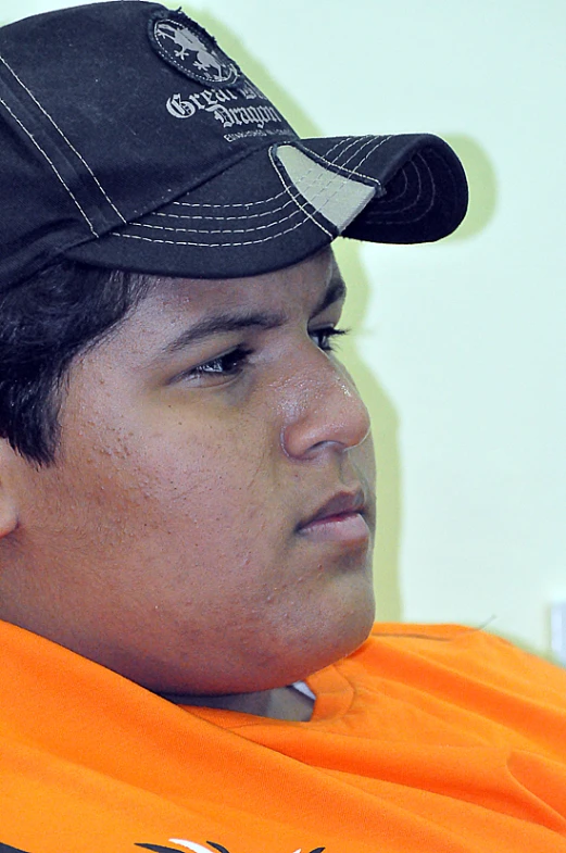 a man in an orange shirt and a black hat