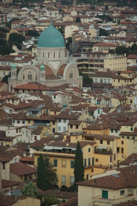 a large building with a domed blue top near some buildings