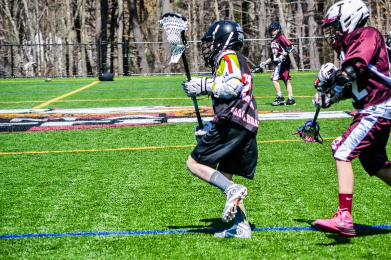 a group of boys in lacrosse uniforms playing ball