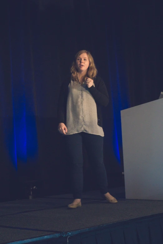 a young woman is giving a speech on stage