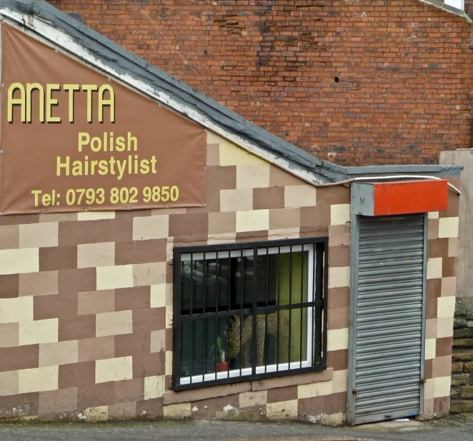 the shop is made out of brick and has a sign reading aneta polish hairstylist