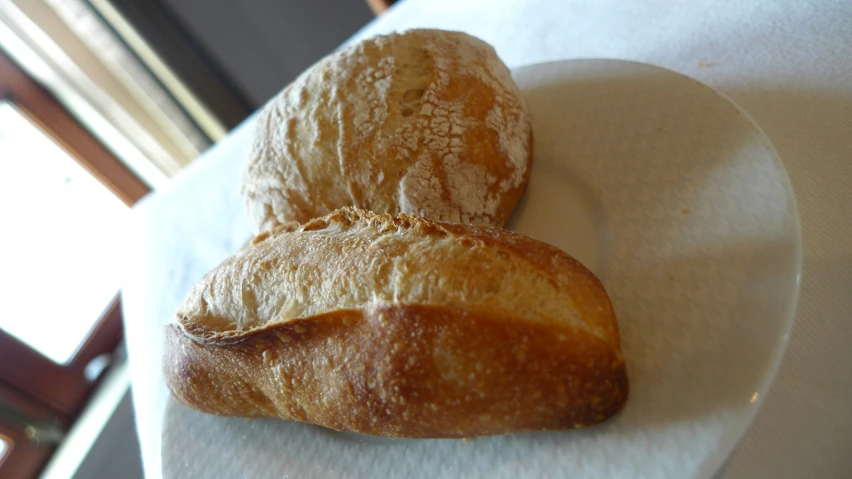 two croissants sitting on a white plate