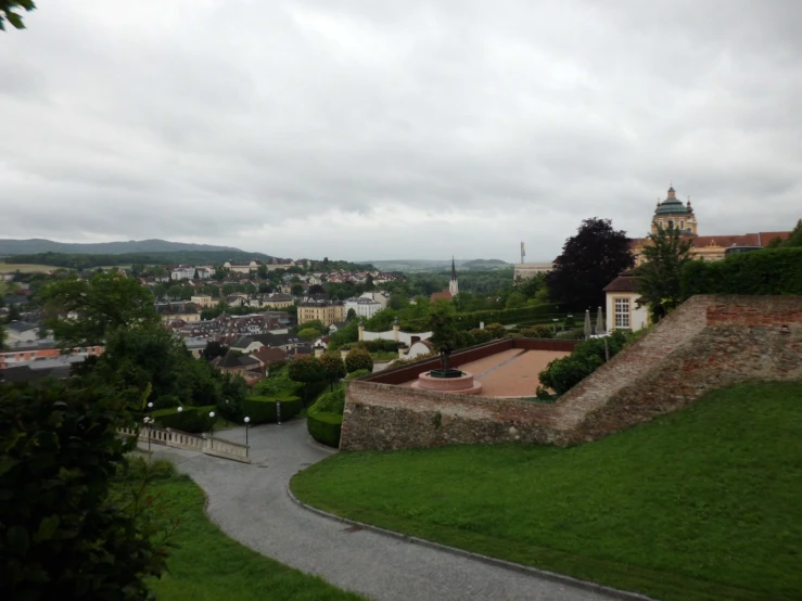 view from the top of a hill towards buildings and grassy area