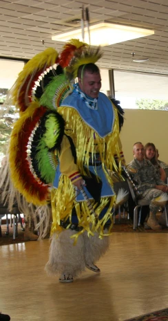 a man dressed up in a colorful dress with feathers