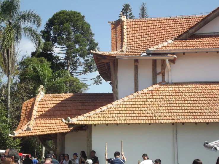 a group of people walking around a building with a crowd in front of it