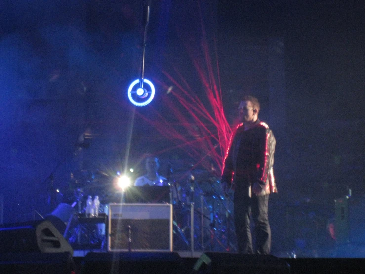 man standing on stage with lights behind him at festival