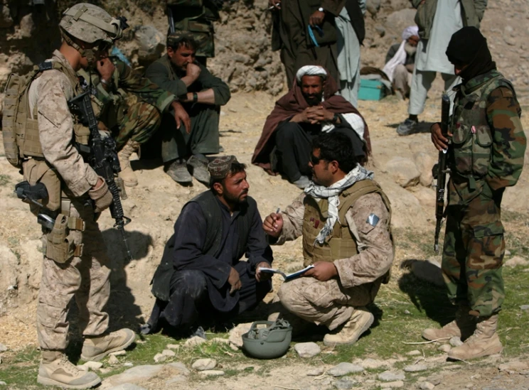 men are talking with an army officer near them
