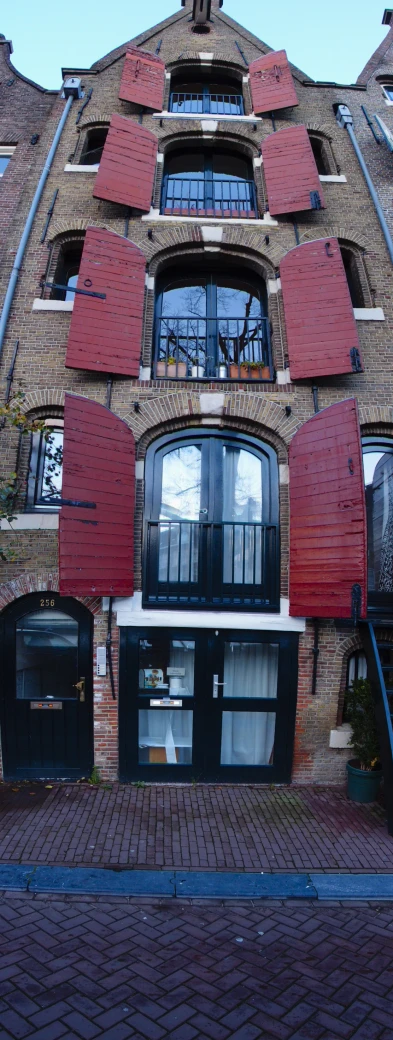 a very big brick building with some shutters open