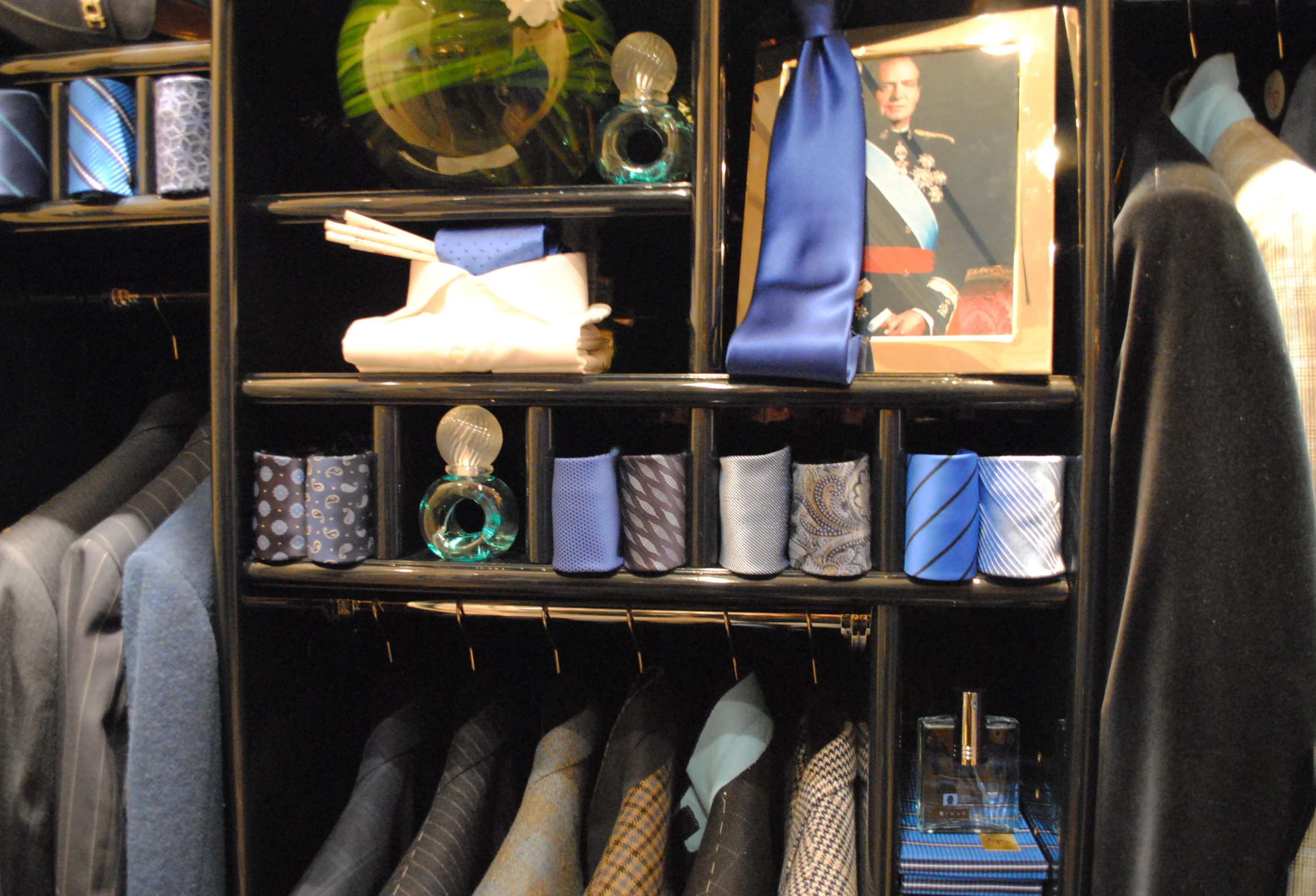 a cabinet with a collection of ties, dress shirts and other things