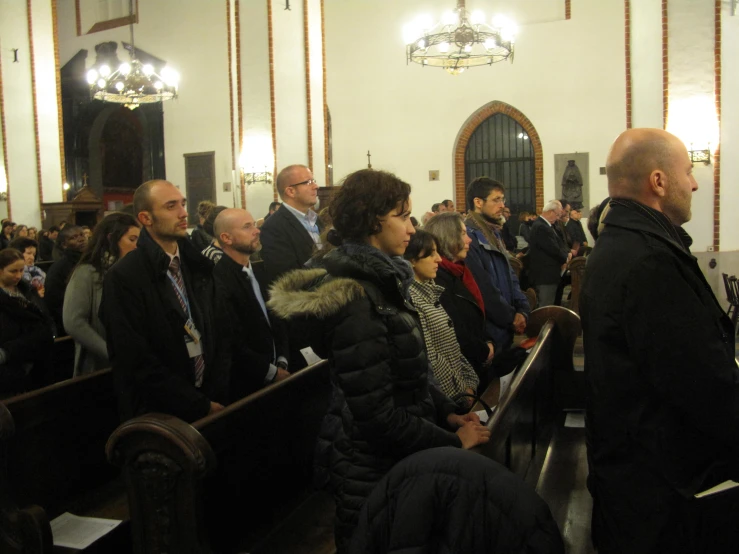 several people in church seats facing the alter