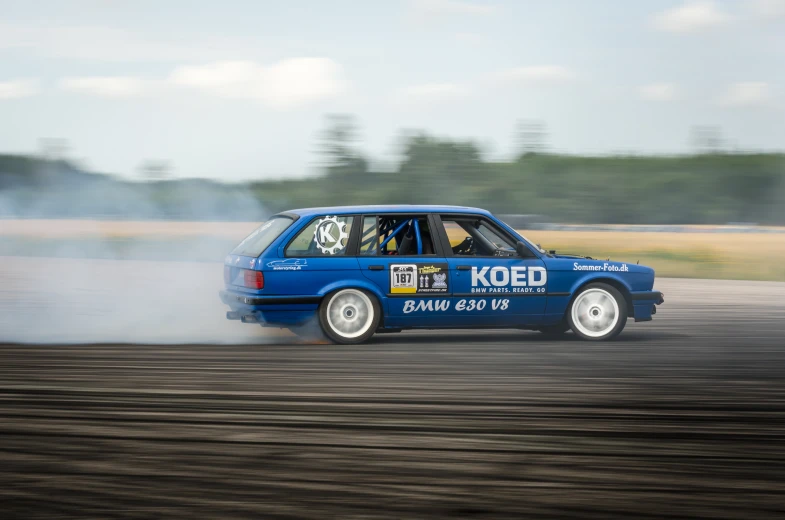 a man driving a car with a smoke stack behind it